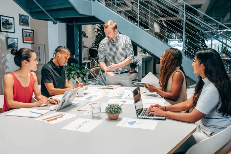 Qué Enseña "La Quinta Disciplina" de Peter Senge sobre Organizaciones 8 equipos colaborando en reunion creativa