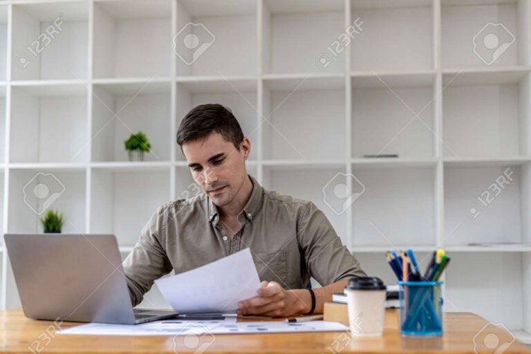 persona estudiando con laptop y documentos financieros