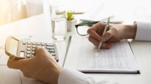 persona firmando documentos con calculadora