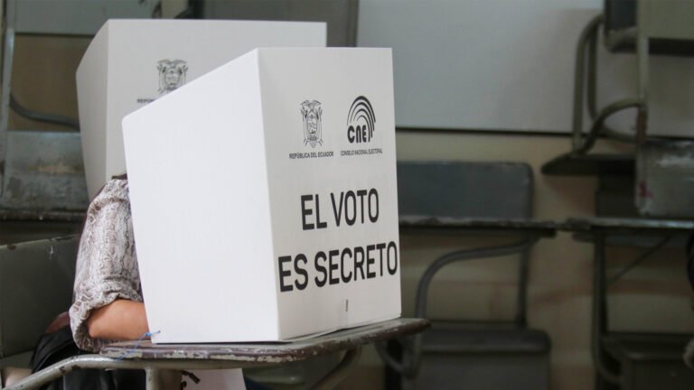 persona frente a urna electoral y mesa de votacion