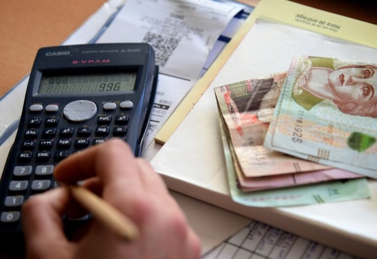 Quiénes tienen derecho al descuento del IVA en Argentina 18 persona usando calculadora con billetes argentinos